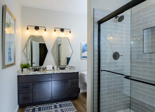 A bathroom with a black vanity and a glass shower. at Fairmont Apartments, Ohio, 43081
