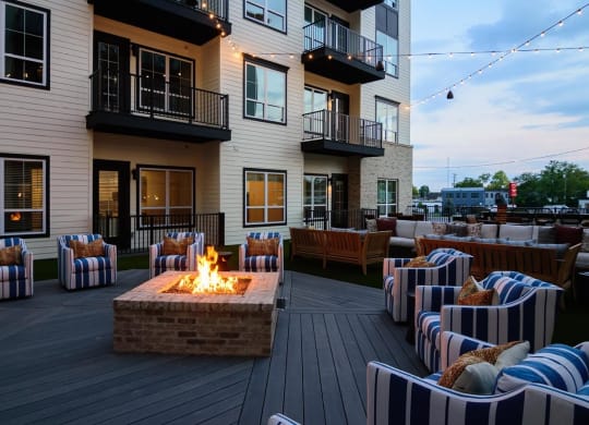 a firepit and seating area on a deck with apartment buildings in the background at Essex, Ohio