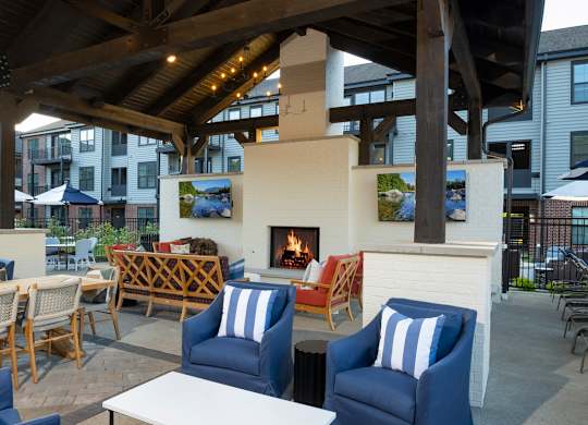 A patio with a fireplace and chairs.