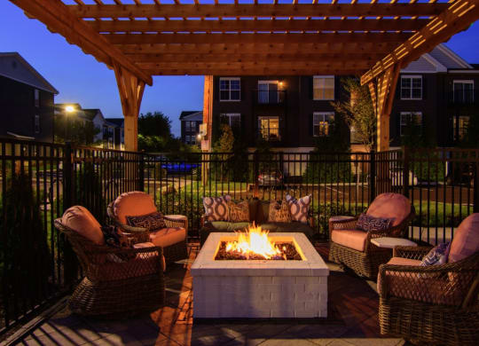 a patio with chairs and a fire pit