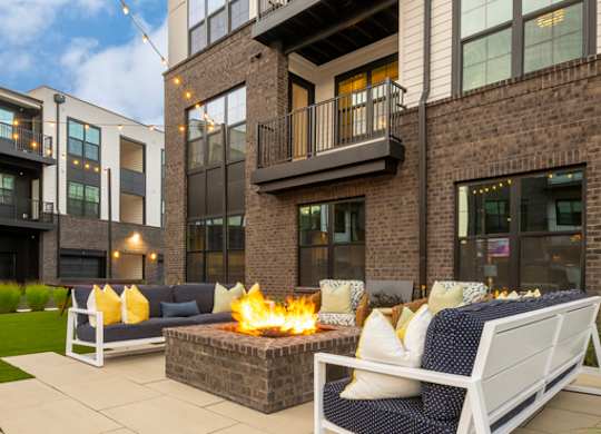 A patio with a fire pit and seating area.