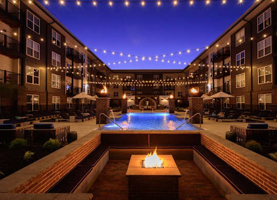 A pool with a fire pit in the middle of it.