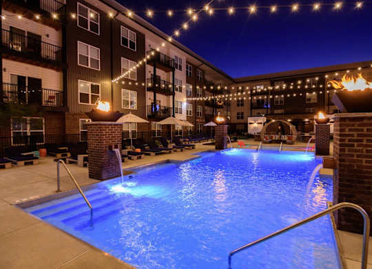 A lit up pool area at night.