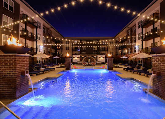 A pool lit up with blue lights at night.