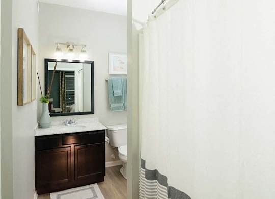 A bathroom with a white toilet and a white shower curtain.