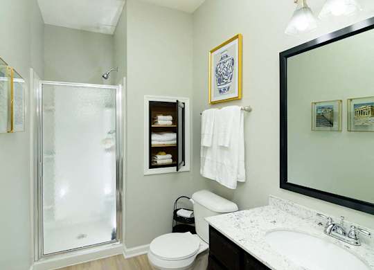 A bathroom with a toilet, sink, and shower.