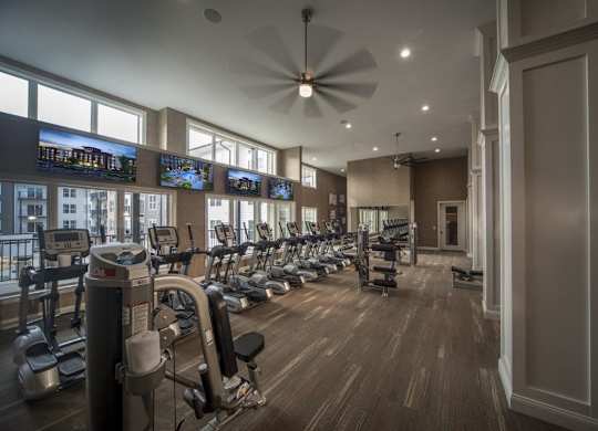 A gym with a variety of equipment including treadmills, stationary bikes, and weight machines.