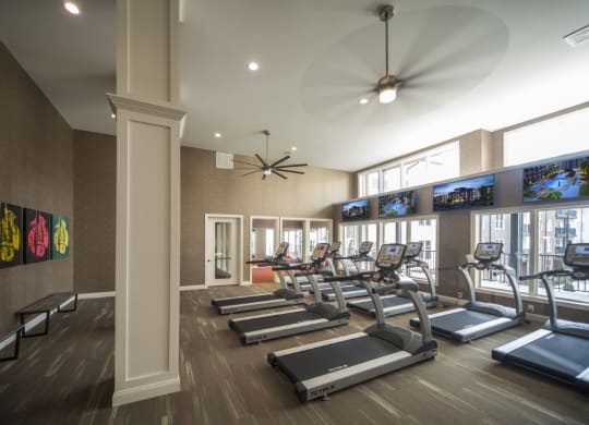 a gym with treadmills and televisions on the wall at Taylor House, Columbus, OH