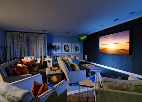 A living room with a large screen on the wall and a couch.