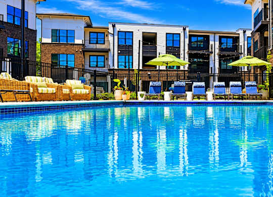 A swimming pool with a reflection of the surrounding buildings.