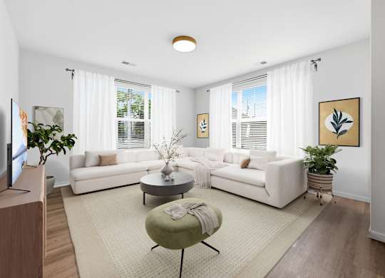 A living room with a white couch, a green ottoman, and a television on the left side.