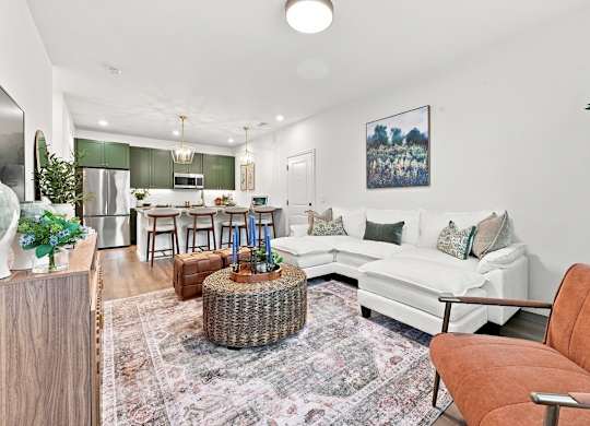A living room with a white couch and a wicker table.