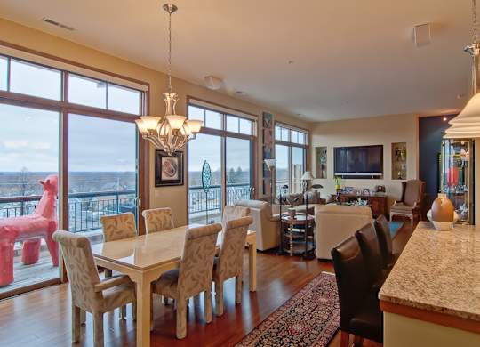 A dining room with a table and chairs and a chandelier at Cornerstone & Ravenna* Apartments, Shorewood