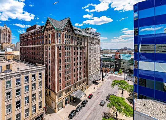 A cityscape with a large building in the foreground and a blue building on the right at Grand Wisconsin, Milwaukee