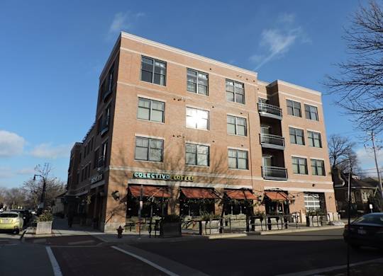 A large brick building with a coffee shop on the ground floor at Cornerstone & Ravenna* Apartments, Shorewood, WI, 53211