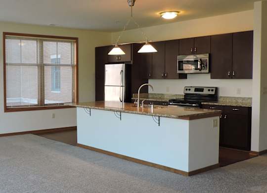 A kitchen with a white countertop and brown cabinets at Cornerstone & Ravenna* Apartments, Wisconsin, 53211