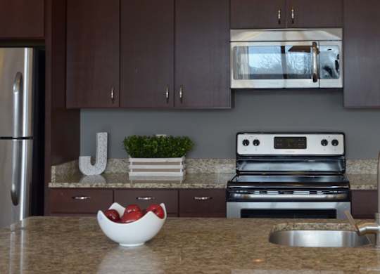 A kitchen with a stainless steel refrigerator and a stove top oven at Cornerstone & Ravenna* Apartments, Wisconsin