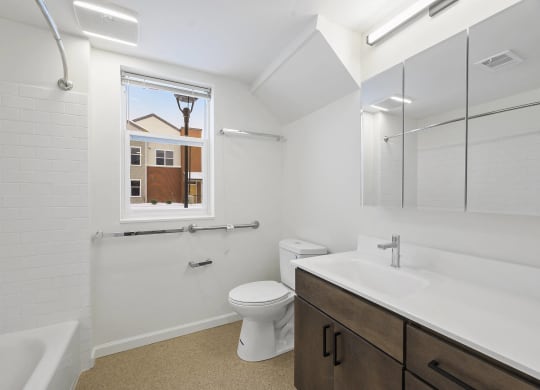 a bathroom with a toilet sink and shower and a window