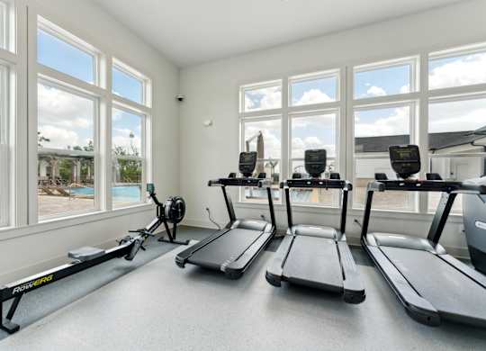 treadmill and row machines in fitness center at The Hendry Apartments, Fort Myers, FL