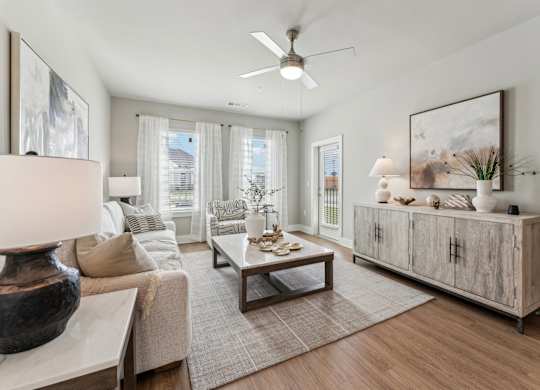 A living room with a couch, a coffee table, and a large painting on the wall at The Hendry Apartments, Fort Myers, 33905