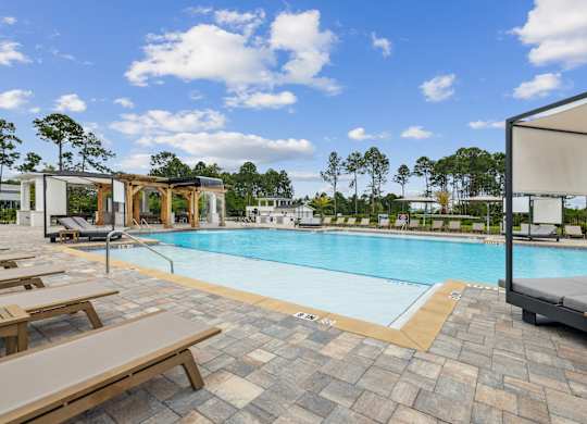 A pool with a sun lounger and a shade structure at The Beacon at 331 Apartments, Santa Rosa Beach, FL