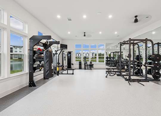 A spacious gym with a variety of equipment and a view of the outside through the windows at The Beacon at 331 Apartments, Santa Rosa Beach, FL