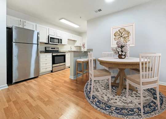 A kitchen with a table and chairs.
