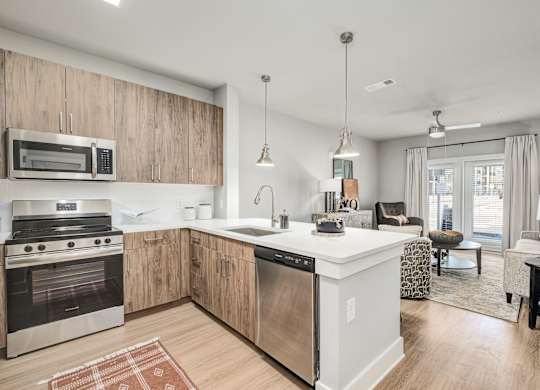A modern kitchen with wooden cabinets and stainless steel appliances at The Ashton at East Park Apartments, Georgia, 30144