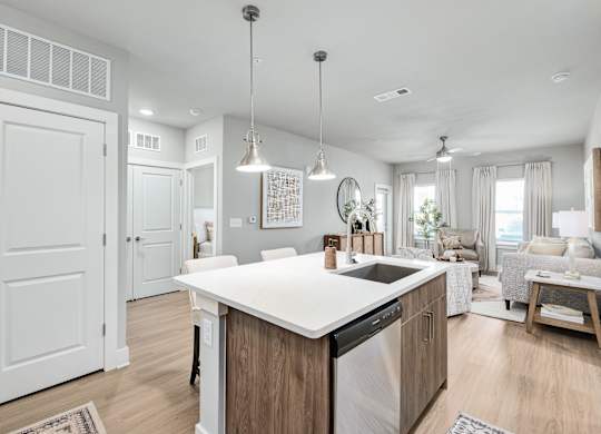 A modern kitchen with a large island and a dining area at The Ashton at East Park Apartments, Kennesaw, 30144