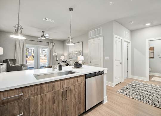 A modern kitchen with wooden cabinets and stainless steel appliances at The Ashton at East Park Apartments, Kennesaw, GA