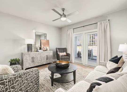 A living room with a black coffee table and a grey sofa at The Ashton at East Park Apartments, Kennesaw, GA, 30144