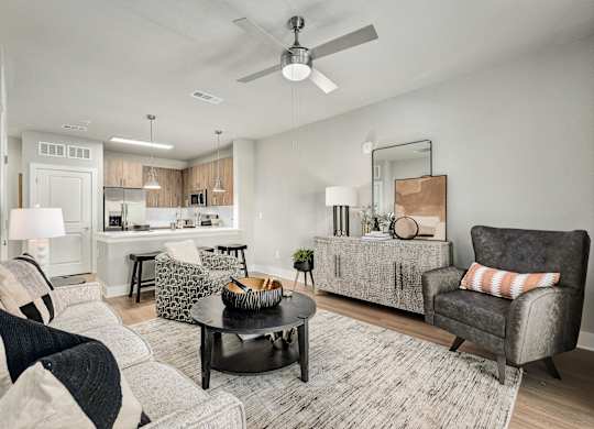 A modern living room with a grey sofa and a black coffee table at The Ashton at East Park Apartments, Kennesaw, Georgia