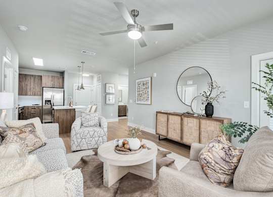 A living room with a white ceiling fan and a white coffee table at The Ashton at East Park Apartments, Kennesaw, GA, 30144