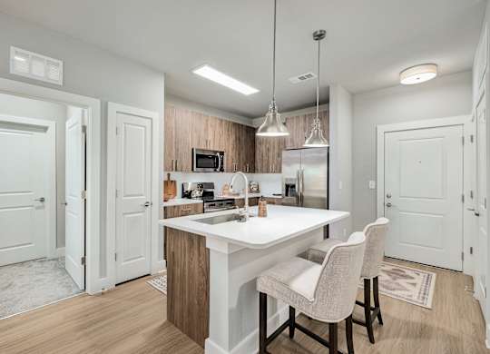 A kitchen with a white countertop and a white dining table with two chairs at The Ashton at East Park Apartments, Kennesaw, GA