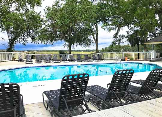 Swimming pool with black chairs at West Wind Landing, Savannah, Georgia.