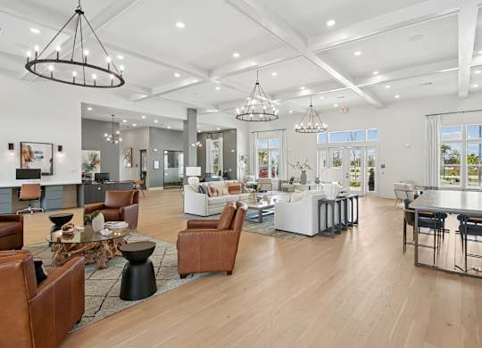 A modern open-concept living space with a kitchen, dining area, and seating options at The Hendry Apartments, Fort Myers, FL