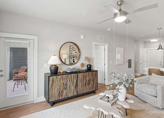 A modern living room with a wooden cabinet and a grey sofa at The Hendry Apartments, Fort Myers, FL