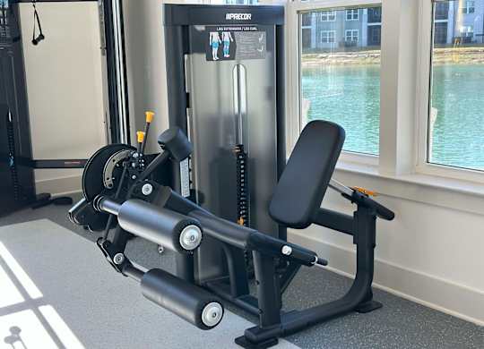 A black and silver gym machine is in front of a window at The Beacon at 331 Apartments, Santa Rosa Beach, FL