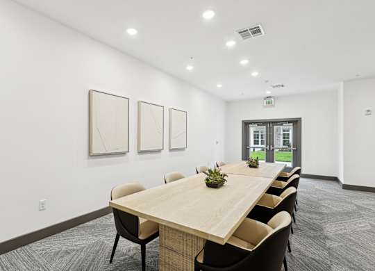 a conference room with white walls and a wooden table and chairs at The Leo Myrtle Beach, Myrtle Beach, SC, 29579