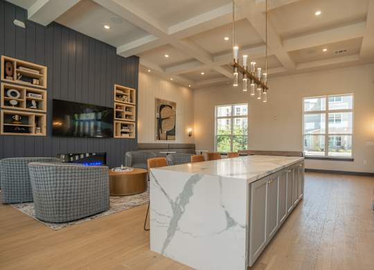 A modern living room with a fireplace and a large marble island at The Ashton at East Park Apartments, Kennesaw, GA