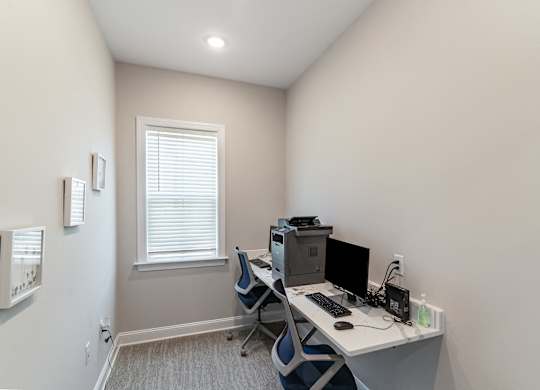 an office with a computer desk and a window