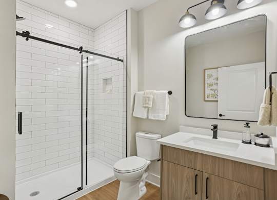 A white toilet sits next to a sink in a bathroom at Union Eleven Apartments, Atlanta, Georgia