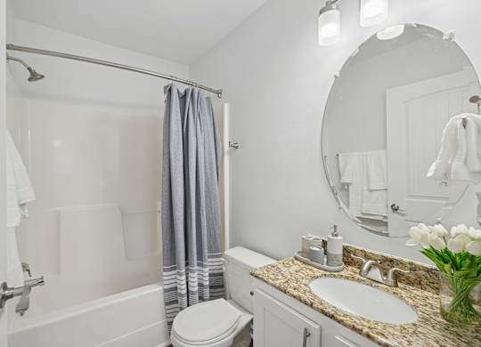 A white bathroom with a toilet, sink, and shower.