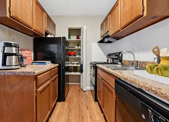 A kitchen with black appliances and wooden cabinets.