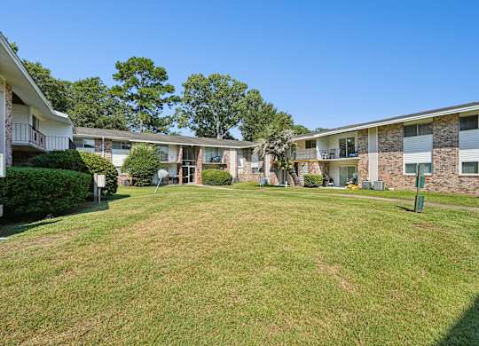 A grassy area in front of apartment buildings.