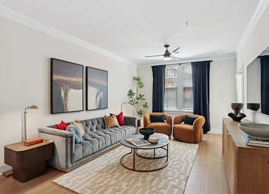 A living room with a grey couch, a coffee table, and a painting on the wall at Union Eleven Apartments, Atlanta, Georgia