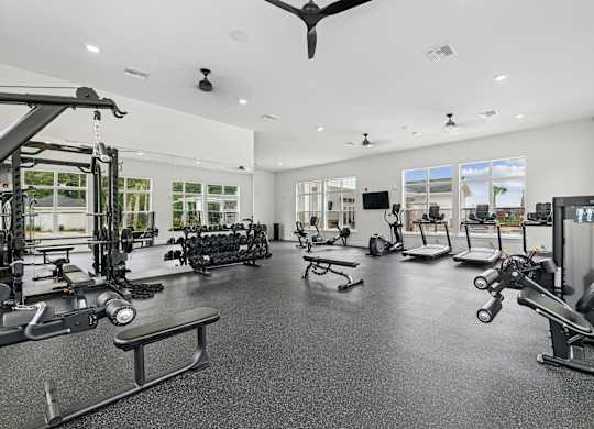 A spacious gym with a variety of equipment and a ceiling fan.at The Exchange at Crestview Apartments, Crestview, 32536