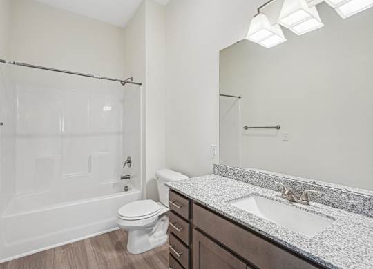 A white bathroom with a toilet, sink, and shower.at The Parker Leland, North Carolina, 28451