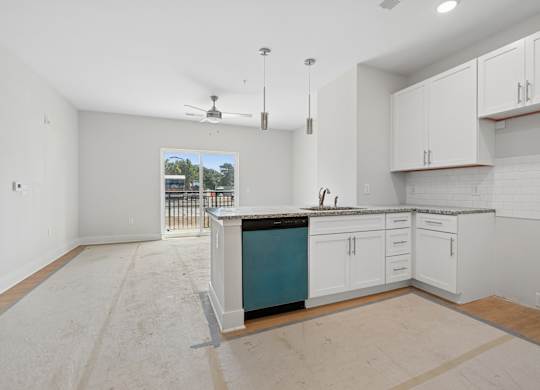 A kitchen with white cabinets and a blue island.