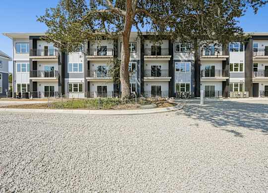 Apartment building with a tree in front.